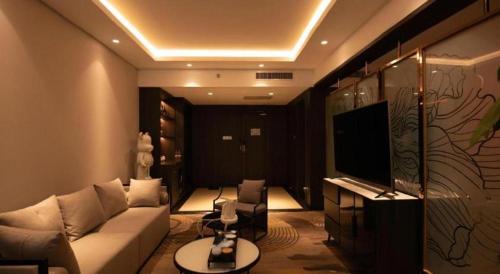 a living room with a couch and a television at New Friendship Hotel in Luoyang