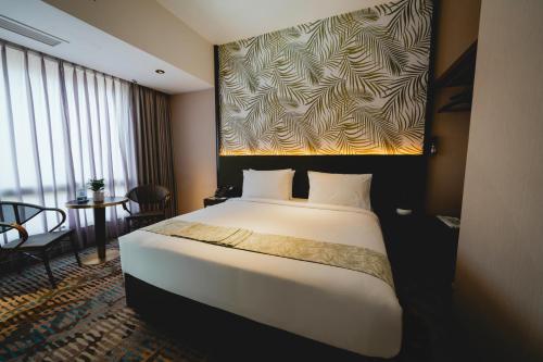 a hotel room with a large bed and a table at Monkeys Canopy Resort in Kajang