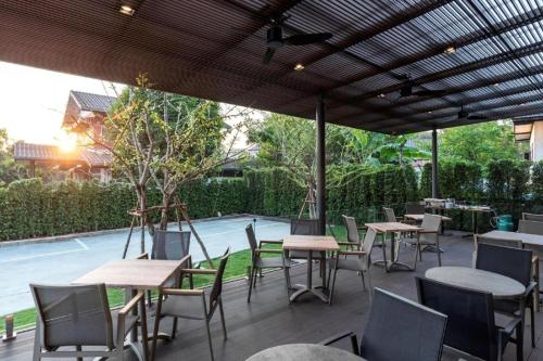 a group of tables and chairs under an umbrella at XOTEL in Khon Kaen