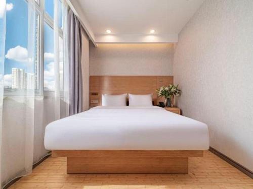 a bedroom with a large bed and a large window at GreenTree Inn Haixi Geermu Southern suburbs Express Hotel in Golmud