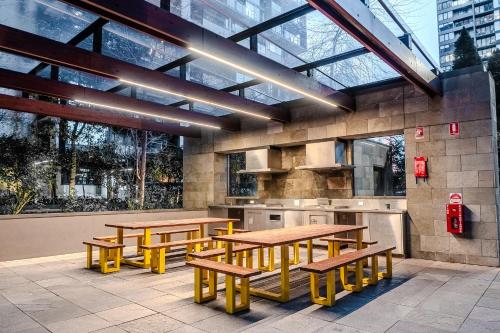 a restaurant with wooden tables and yellow benches at Upper West Side Spencer Heights 2BR 1Car in Melbourne