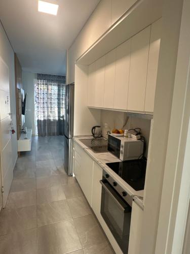 a kitchen with white cabinets and a microwave at San Pietro Apartment- Gjiri i Lalezit in Lalzit Bay
