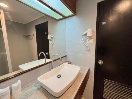 a bathroom with a sink and a mirror at Napalai Hotel in Udon Thani