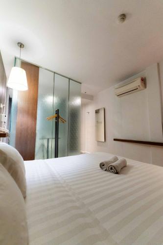 a bedroom with a bed with two towels on it at T+ Hotel Butterworth in Butterworth