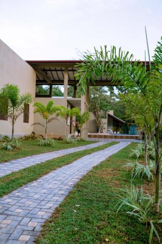 a stone path in front of a building at NatureSurf Villas - Private Garden Retreat at Hiriketiya Beach Yoga, Surf & Relaxation in Dickwella