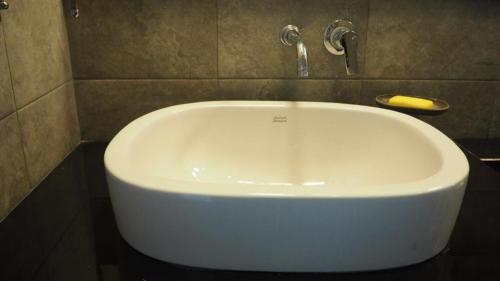 a white bath tub in a bathroom at Maximize Brand New Hostel Udonthani in Udon Thani