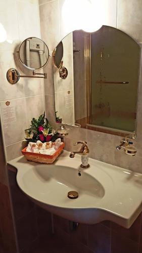 a bathroom with a sink with a mirror and a mirror at Hotel Elit Palace and SPA in Balchik