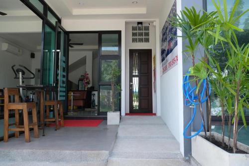an open door of a house with a table and chairs at The Smart Hostel in Nakhon Ratchasima