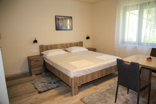 une chambre avec un lit, un bureau et une table dans l'établissement AKZ Apartman, à Makó