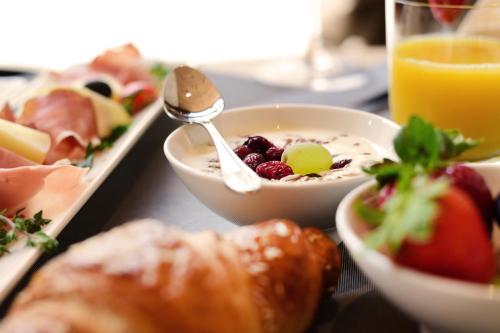 a table topped with bowls of food and a spoon at Das Alte Rathaus in Egna