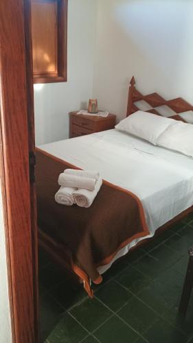 a bedroom with a bed with towels on it at Casa com piscina para até 6 pessoas com duas camas de casal e sofá-cama casal in Serra Negra