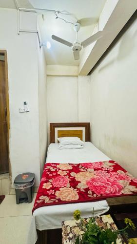 a bedroom with a bed with a red blanket at Hotel New Royal Palace Dhanmondi in Dhaka