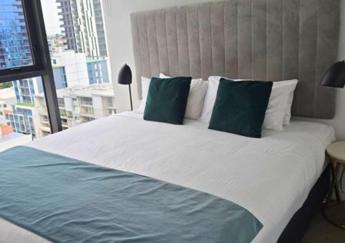 a bedroom with a large bed with a large window at Neat and Cozy 1BR Apartment with Amazing Facilities in Brisbane
