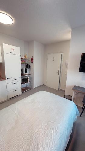 a bedroom with a white bed and a desk at Nisay Home, Apart Suite, N1 in Ludwigsburg