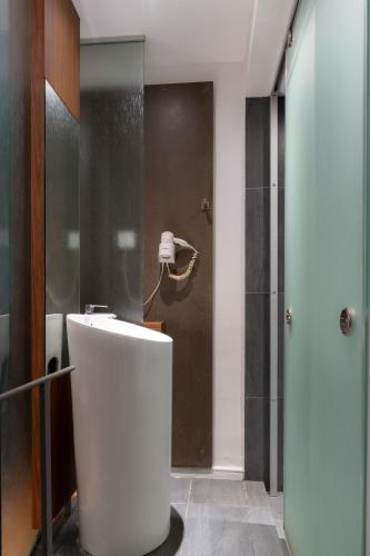 a bathroom with a white sink and a shower at T+ Hotel Butterworth in Butterworth