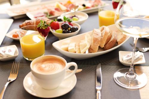 a table topped with plates of food and a cup of coffee at Das Alte Rathaus in Egna