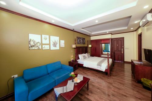 a hotel room with a bed and a couch at La Palm Garden - Luang prabang in Luang Prabang