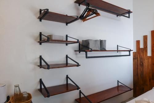 a wall with three wooden shelves on a wall at AV Suites in Puerto Galera