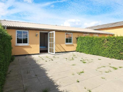 a yellow house with a patio and a fence at 6 person holiday home in Faaborg-By Traum in Fåborg