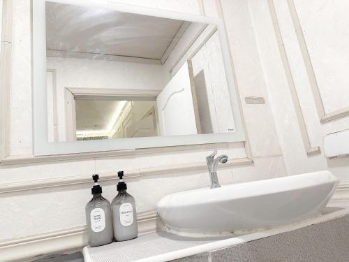 a bathroom sink with a mirror and two bottles on it at X Casa Sukhumvit 11 BTS Nana -คาซ่า สุขุมวิท 11 บีทีเอสนานา in Bangkok