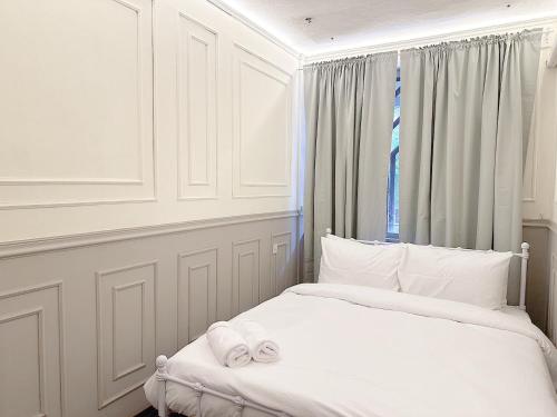 a white bedroom with a bed with towels on it at X Casa Sukhumvit 11 BTS Nana -คาซ่า สุขุมวิท 11 บีทีเอสนานา in Bangkok