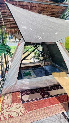 a bed in a tent on the ground at HOMESTAY Hoàng GIa in Ấp Ông Tú