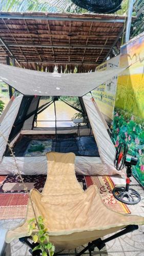 a hammock in a tent in a room at HOMESTAY Hoàng GIa in Ấp Ông Tú