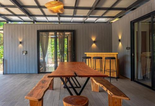 a wooden table and stools in a room at Trumpet Deck 3BHK Container Home in Kutta