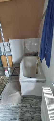 a white bath tub in a bathroom with blue towels at Bed vue sur vallée de la Meuse Namur in Bouge