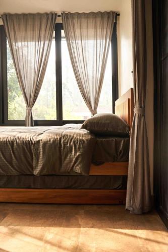 a bed in a bedroom with a large window at Trumpet Deck 3BHK Container Home in Kutta