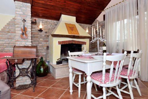 een eetkamer met een tafel en een open haard bij Rustic house with private swimming pool in Pula