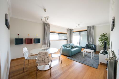 a living room with a table and a blue couch at Porto RiverSea Quay Apartment in Matosinhos