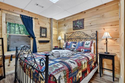 a bedroom with a bed in a room with wooden walls at Papa Bear's Den in Cherry Log