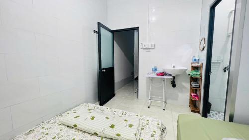 a small room with a bed and a sink at HOMESTAY Hoàng GIa in Ấp Ông Tú