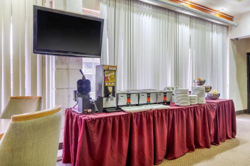 a table with a red table cloth and a television at Quality Inn Piedras Negras in Piedras Negras