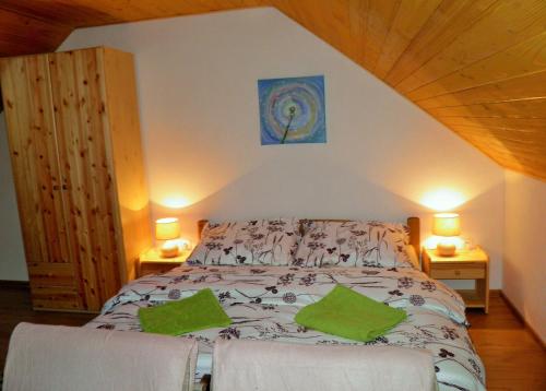 sypialnia z łóżkiem z zielonymi poduszkami w obiekcie Green cottage Besenova w Beszeniowej