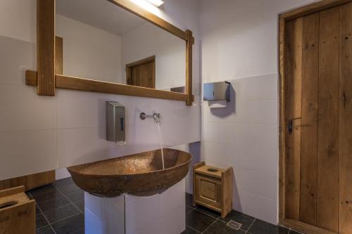 a bathroom with a wooden sink and a mirror at Hanul Vatra in Horezu