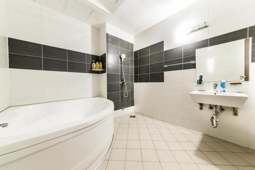 a white bathroom with a tub and a sink at Nostalgia Hotel in Paju