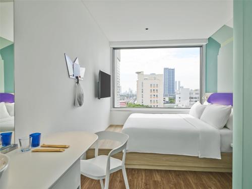 a bedroom with a white bed and a window at Tru by Hilton Da Nang City Centre in Da Nang