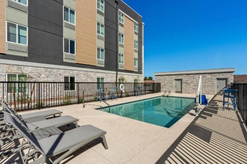 a swimming pool with a chair and a building at Everhome Suites Yuma East I-8 by Choice Hotels in Yuma