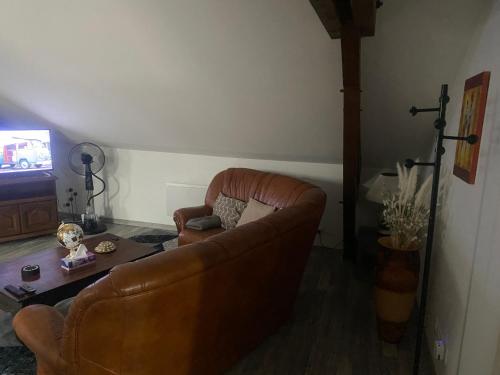 a living room with a couch and a television at Le Barbès in Montceau-les-Mines