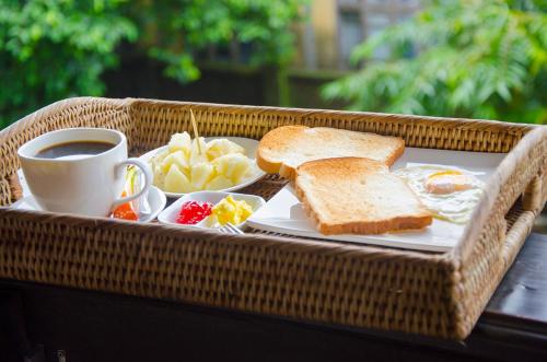 a breakfast tray with toast and a cup of coffee at Shannkalay Hostel in Yangon