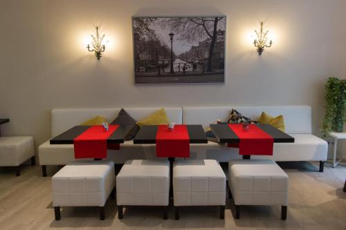 a dining room with a table and chairs with red cross cushions at France Hotel in Amsterdam