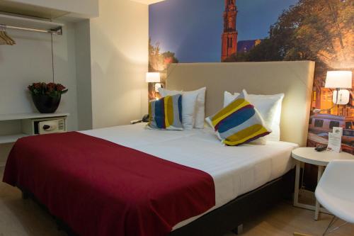 a hotel room with a large bed with pillows at France Hotel in Amsterdam