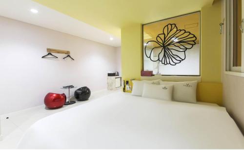 a bedroom with a large bed with a flower picture on the wall at Songjeong V Hotel in Busan