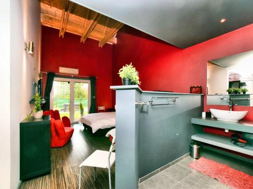 a red room with a sink and a bed at Beautiful villa with heated outdoor pool in Manhay