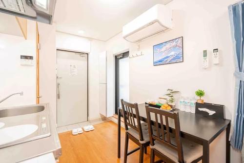 a kitchen with a table and two chairs and a sink at Akihabara Skytree Premium Apartment 401 in Tokyo
