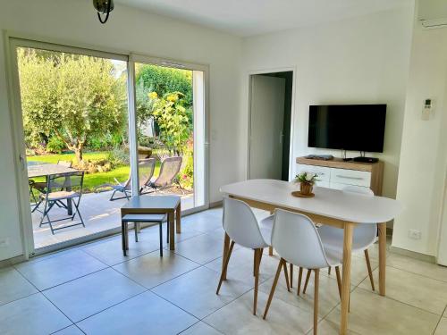 a dining room with a table and chairs and a television at Mini Villa Pascal Paoli avec piscine - proche mer in Prunelli-di-Fiumorbo