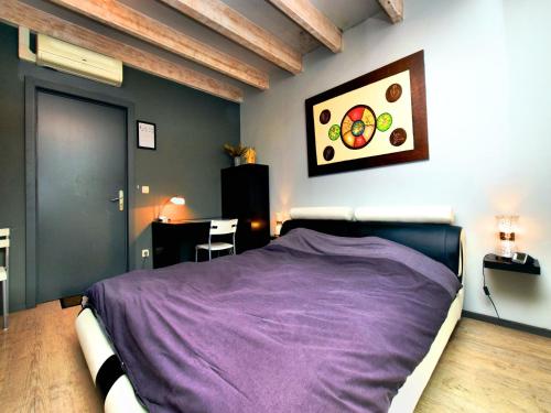 a bedroom with a bed with a purple blanket at Beautiful villa with heated outdoor pool in Manhay