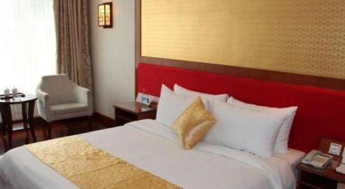 a bedroom with a large bed with a red headboard at Golden Lustre Hotel in Shenzhen